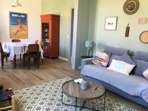un salon avec un canapé bleu et une table dans l'établissement Résidence 092-soulac Sur Mer - 092 - Villa Soulacaise avec dépendance à 250m du centre et du marché MAE-9421, à Soulac-sur-Mer