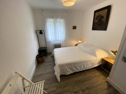 une chambre avec un lit blanc et une fenêtre dans l'établissement Résidence 008-soulac Sur Mer - 008 - Jolie villa contemporaine avec piscine MAE-6151, à Soulac-sur-Mer