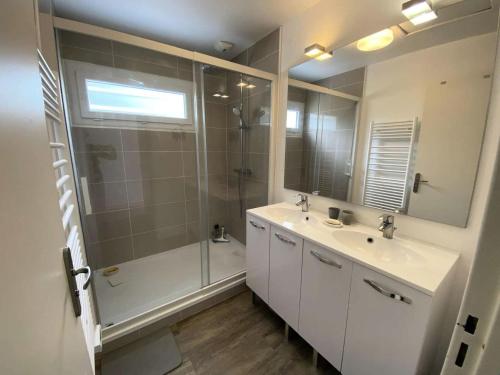 une salle de bain avec une douche, un lavabo et un miroir dans l'établissement Résidence 008-soulac Sur Mer - 008 - Jolie villa contemporaine avec piscine MAE-6151, à Soulac-sur-Mer