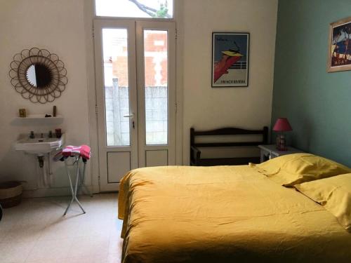 - une chambre avec un lit jaune et un lavabo dans l'établissement Résidence 092-soulac Sur Mer - 092 - Villa Soulacaise avec dépendance à 250m du centre et du marché MAE-9421, à Soulac-sur-Mer