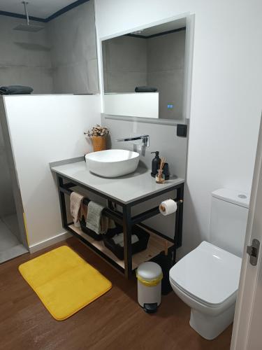a bathroom with a sink and a toilet at Kings B&B Eiras in Caniço