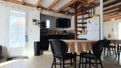 une cuisine et une salle à manger avec une table et des chaises dans l'établissement Résidence 042-soulac Sur Mer - 042 - Charmante maison de vacances à Soulac-sur-Mer, à deux pas de la plage MAE-2321, à Soulac-sur-Mer