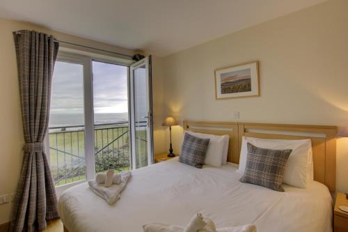 a bedroom with a bed and a large window at No10 The Links Apartment, Brora in Brora