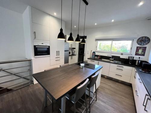 une grande cuisine avec une table et des chaises en bois dans l'établissement Résidence 049-soulac Sur Mer - 049 - Spacieuse villa proche du centre-ville MAE-2351, à Soulac-sur-Mer