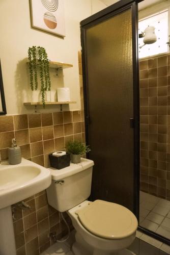 un bagno con wc, lavandino e doccia di Pool House Hostel a Santa Ana