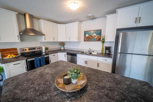 a kitchen with white cabinets and a granite counter top at 3 Bedroom Townhouse with Mountain Views, Large Deck, Garage in Invermere