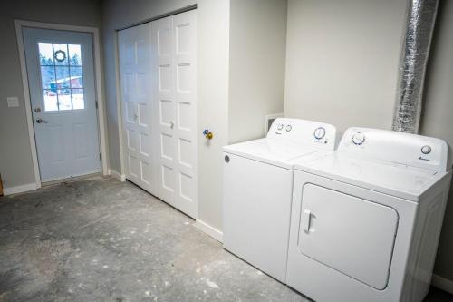 a white laundry room with a washer and dryer at 3 Bedroom Townhouse with Mountain Views, Large Deck, Garage in Invermere