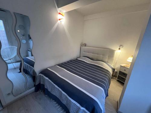 Cette petite chambre comprend un lit avec des draps bleus et blancs. dans l'établissement Résidence Avé Maria - 026 - Magnifique appartement avec vue imprenable sur la mer MAE-3561, à Soulac-sur-Mer