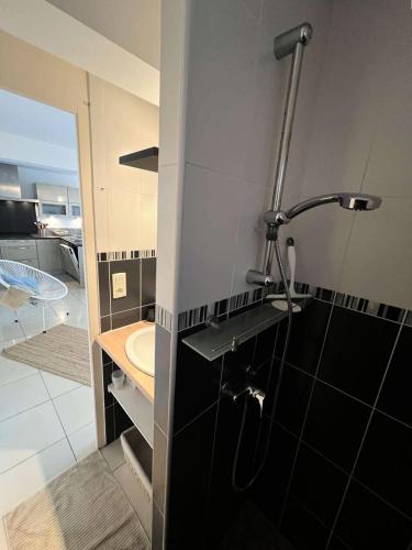 La salle de bains est pourvue d'un lavabo et d'une douche. dans l'établissement Résidence Avé Maria - 026 - Magnifique appartement avec vue imprenable sur la mer MAE-3561, à Soulac-sur-Mer