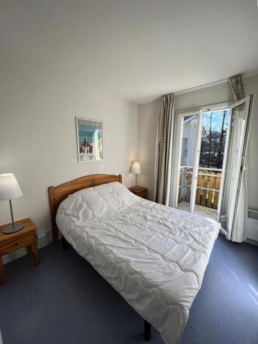 une chambre avec un lit et une grande fenêtre dans l'établissement Résidence Domaine Des Sables - 036 - Maison mitoyenne dans un domaine de vacances avec piscine MAE-3581, à Soulac-sur-Mer