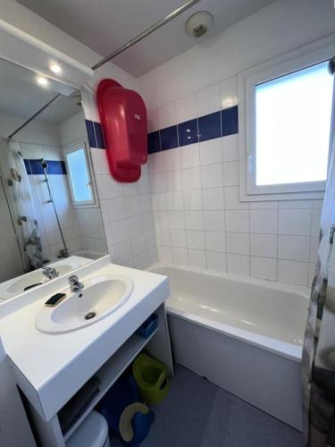 une salle de bain avec un lavabo et une baignoire dans l'établissement Résidence Domaine Des Sables - 036 - Maison mitoyenne dans un domaine de vacances avec piscine MAE-3581, à Soulac-sur-Mer