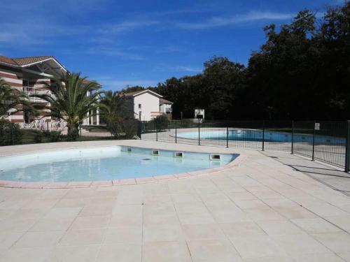 une grande piscine entourée d'une clôture. dans l'établissement Résidence Domaine Des Sables - 037 - Agréable maison mitoyenne dans une résidence de vacances 3 étoiles MAE-3601, à Soulac-sur-Mer