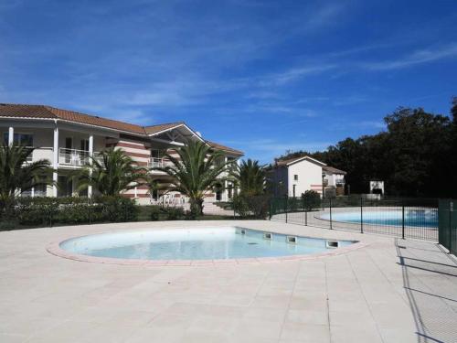 une grande piscine devant une maison dans l'établissement Résidence Domaine Des Sables - 073 - Domaine des Sables classé 3 étoiles maison en duplex MAE-3651, à Soulac-sur-Mer