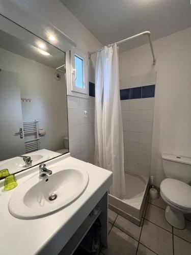 une salle de bain avec un lavabo, des toilettes et un miroir dans l'établissement Résidence Domaine Des Sables - 073 - Domaine des Sables classé 3 étoiles maison en duplex MAE-3651, à Soulac-sur-Mer