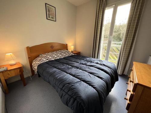 une chambre avec un lit et une fenêtre dans l'établissement Résidence Domaine Des Sables - 073 - Domaine des Sables classé 3 étoiles maison en duplex MAE-3651, à Soulac-sur-Mer