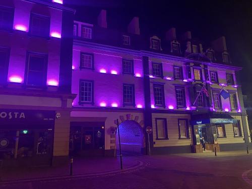 a building with purple lights on it at night at Carlisle Station Hotel, Sure Hotel Collection by BW in Carlisle