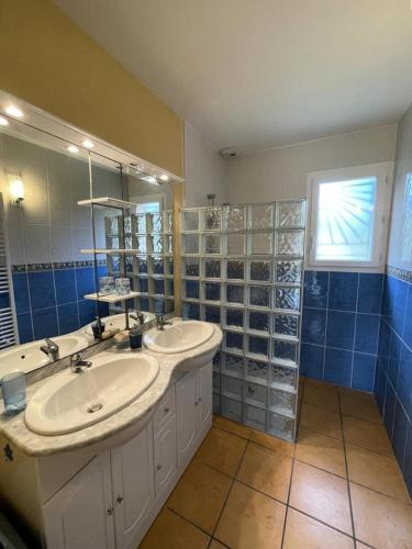 une salle de bain avec deux lavabos et un grand miroir dans l'établissement Résidence 060-soulac Sur Mer - 060 - Agréable maison avec jardin à Soulac/mer MAE-3641, à Soulac-sur-Mer