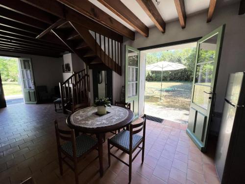 une salle à manger avec une table, des chaises et un parasol dans l'établissement Résidence 106-st Vivien De Medoc - 106 - Agréable maison avec son grand parc MAE-3681, à Saint-Vivien-de-Médoc