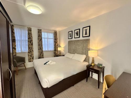 a hotel room with a bed and a table with a lamp at Carlisle Station Hotel, Sure Hotel Collection by BW in Carlisle