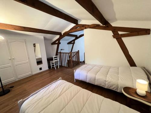 - une chambre avec un lit dans une pièce dotée de poutres apparentes dans l'établissement Résidence 106-st Vivien De Medoc - 106 - Agréable maison avec son grand parc MAE-3681, à Saint-Vivien-de-Médoc