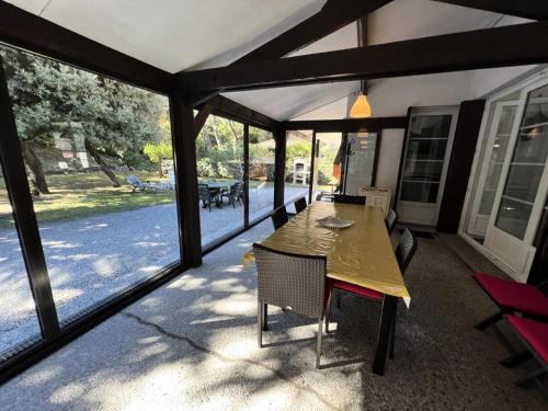 a screened in porch with a table and chairs at Résidence 090-soulac Sur Mer - 090 - Agréable maison avec tout confort à 350m de la plage MAE-3701 in Soulac-sur-Mer