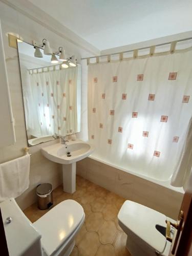 a bathroom with a sink and a toilet and a tub at Merino Casa Rural in Yunquera