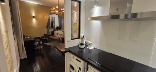 une cuisine avec un comptoir noir dans une pièce dans l'établissement NOVA - - love room & suite, à Libourne