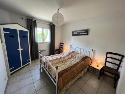 - une chambre avec un lit et une porte bleue dans l'établissement Résidence La Grande Combe - 012 - Agréable villa dans quartier calme de Soulac/mer MAE-3721, à Soulac-sur-Mer