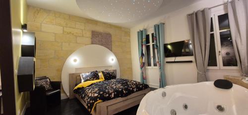 une chambre avec un lit et une baignoire dans l'établissement NOVA - - love room & suite, à Libourne