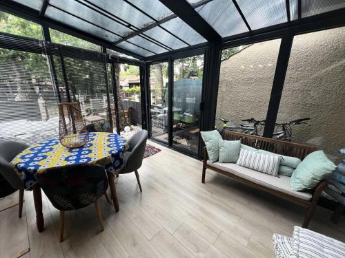 une véranda avec une table et un canapé dans l'établissement Résidence Villa Atlantique - 020 - Maisonnette au calme dans une petite résidence familiale MAE-9611, à Soulac-sur-Mer