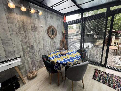 une salle à manger avec une table et des chaises et une fenêtre dans l'établissement Résidence Villa Atlantique - 020 - Maisonnette au calme dans une petite résidence familiale MAE-9611, à Soulac-sur-Mer