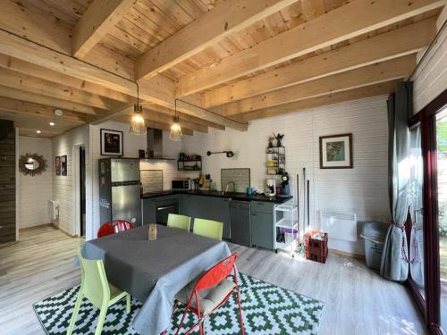 une cuisine et une salle à manger avec une table et des chaises dans l'établissement Résidence 079-soulac Sur Mer - 079 - Maison en bois décorée avec goût MAE-9691, à Soulac-sur-Mer