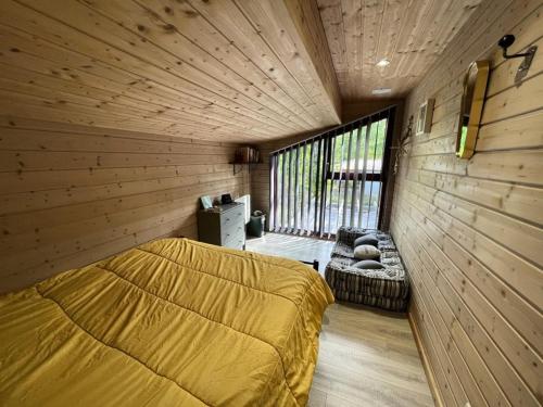 Cette chambre comprend un lit, une fenêtre et un canapé. dans l'établissement Résidence 079-soulac Sur Mer - 079 - Maison en bois décorée avec goût MAE-9691, à Soulac-sur-Mer