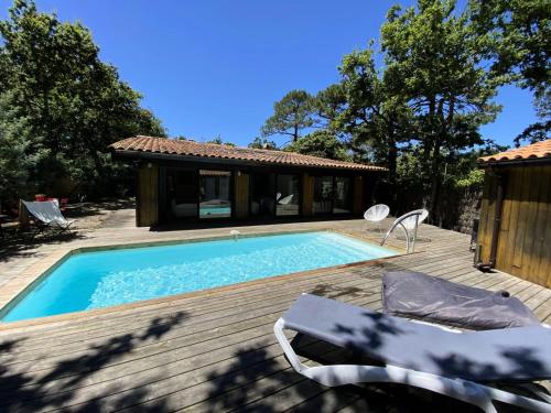 une piscine sur une terrasse à côté d'une maison dans l'établissement Résidence Terres Marine - 099 -Villa d'exception avec piscine à 2 mns des plages des Naïades MAE-9721, à Soulac-sur-Mer