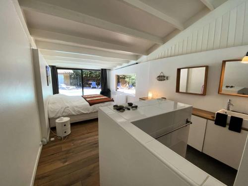 - une cuisine avec évier et un lit dans une chambre dans l'établissement Résidence Terres Marine - 099 -Villa d'exception avec piscine à 2 mns des plages des Naïades MAE-9721, à Soulac-sur-Mer
