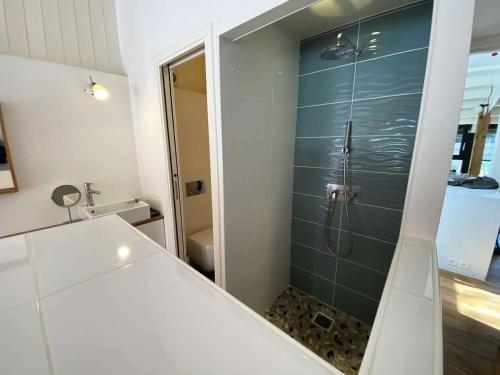 une salle de bain avec une douche avec une porte vitrée dans l'établissement Résidence Terres Marine - 099 -Villa d'exception avec piscine à 2 mns des plages des Naïades MAE-9721, à Soulac-sur-Mer