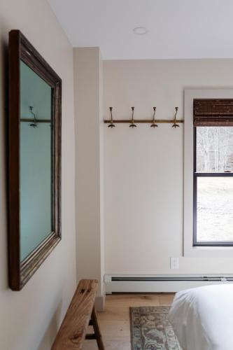 a bedroom with a mirror and a bed and a window at The Bend in Phoenicia