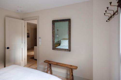 a bedroom with a mirror on a white wall at The Bend in Phoenicia