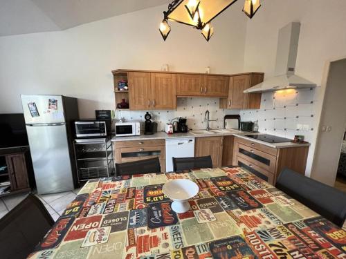 une cuisine avec une table recouverte d'une nappe dans l'établissement Résidence 071-soulac Sur Mer - 071 - Agréable maison avec son grand jardin MAE-1901, à Soulac-sur-Mer