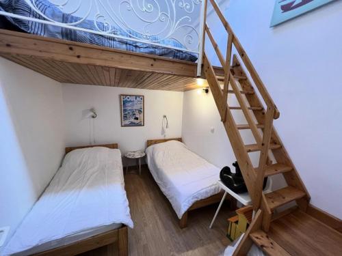 - 2 lits dans une petite chambre avec un escalier dans l'établissement Résidence 071-soulac Sur Mer - 071 - Agréable maison avec son grand jardin MAE-1901, à Soulac-sur-Mer