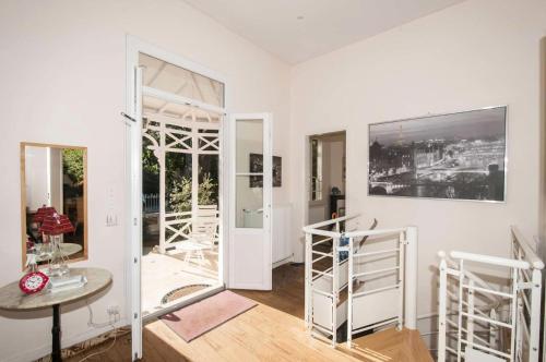 Cette chambre dispose de murs blancs, d'une table et de portes en verre. dans l'établissement Résidence 001-soulac Sur Mer - 001 - Très Belle villa Soulacaise à 5mns du centre MAE-5401, à Soulac-sur-Mer