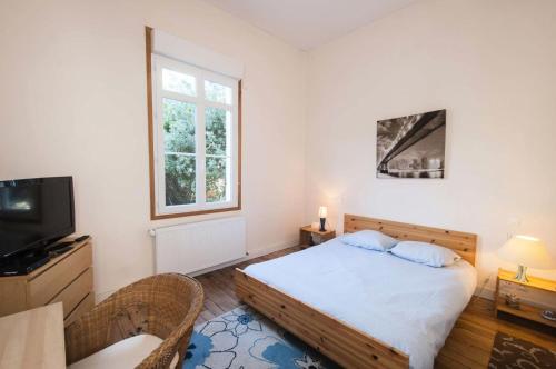 une petite chambre avec un lit et une télévision dans l'établissement Résidence 001-soulac Sur Mer - 001 - Très Belle villa Soulacaise à 5mns du centre MAE-5401, à Soulac-sur-Mer