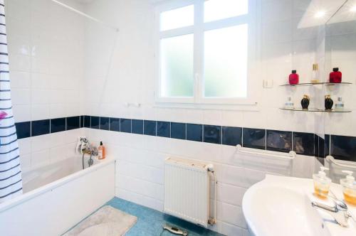 une salle de bain blanche avec un lavabo et une fenêtre dans l'établissement Résidence 001-soulac Sur Mer - 001 - Très Belle villa Soulacaise à 5mns du centre MAE-5401, à Soulac-sur-Mer