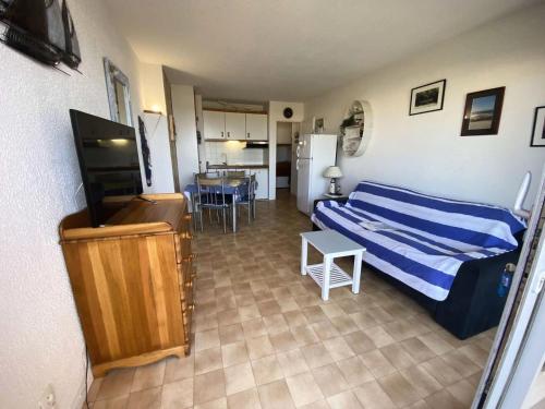 une chambre avec un lit, une télévision et une table dans l'établissement Résidence Cap Atlantic - 063 - Appartement avec jardin en front de mer MAE-1961, à Soulac-sur-Mer