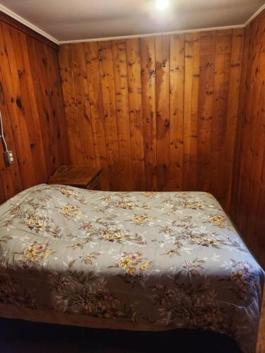 a bed in a room with wood paneled walls at big kahuna in Steuben