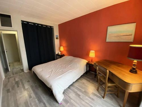 a bedroom with a bed and a desk with two lamps at Résidence De France - 144 - Appartement en plein cœur du Vieux Soulac MAE-4161 in Soulac-sur-Mer