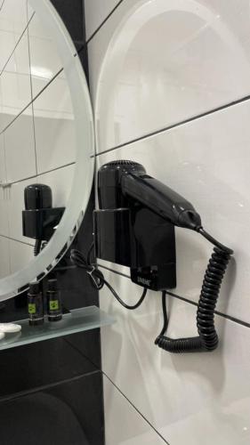 a black phone on a wall next to a mirror at Melirito in Olympiada