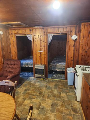 a room with two beds and a table in a cabin at big kahuna in Steuben
