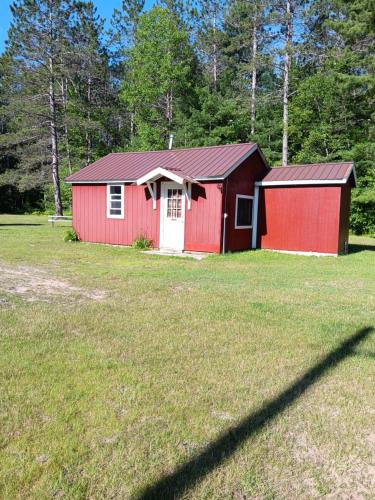 a red barn with a white door in a field at big kahuna in Steuben