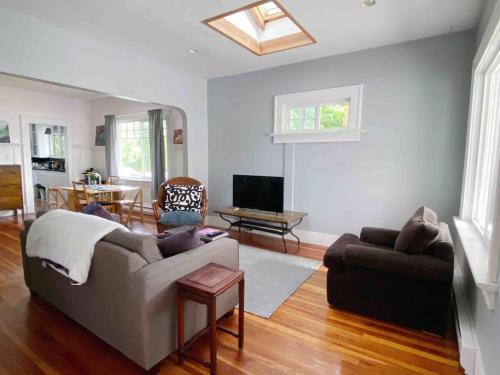 a living room with a couch and a tv at Craftsman Home in popular East Village in Vancouver